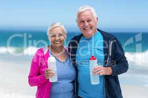 Cute mature couple holding water bottle