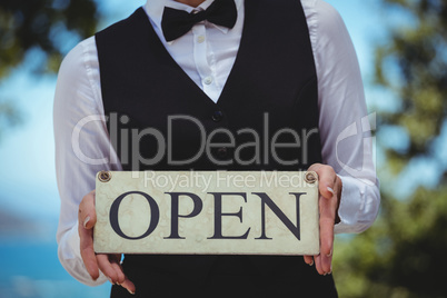 Waitress holding open sign