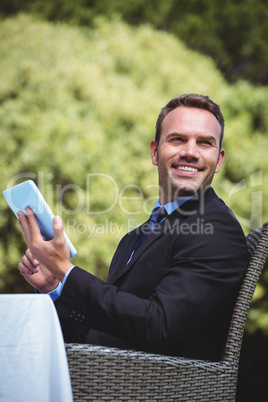 Smiling businessman using tablet