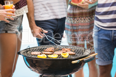 Mid section of friends preparing barbecue