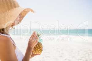 Woman drinking cocktail in pineapple