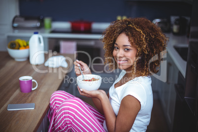 Young woman having breakfast in kitchen