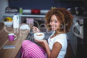 Young woman having breakfast in kitchen