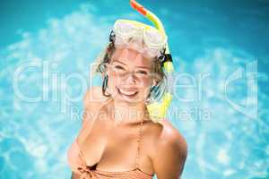 Portrait of woman sitting by swimming pool with a snorkel