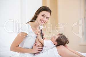 Portrait of smiling mother with baby holding mobile phone