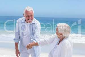 Senior couple playing at the beach