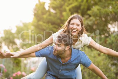 Happy man carrying woman on back