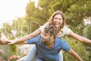 Happy man carrying woman on back