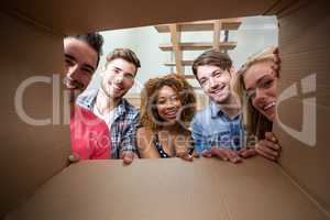 Cheerful friends seen through cardboard box