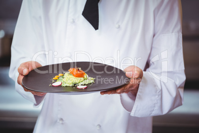 Chef holding and showing a dish