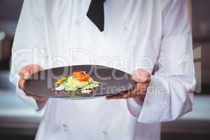 Chef holding and showing a dish