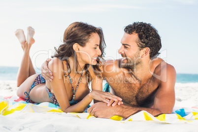 Couple lying on a towel at the beach