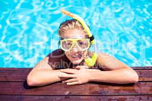 Happy woman with snorkel gear leaning on pool side