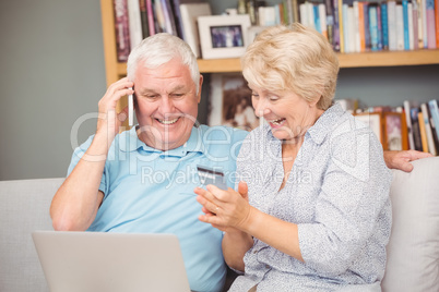 Excited senior couple using laptop