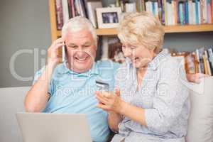 Excited senior couple using laptop