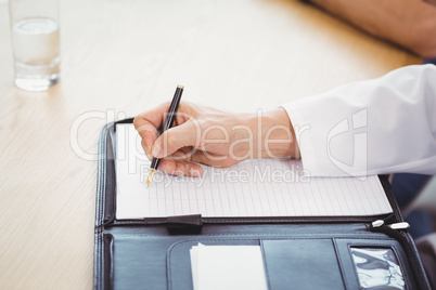 Male doctors hand writing on file