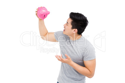 Young man holding a piggy bank