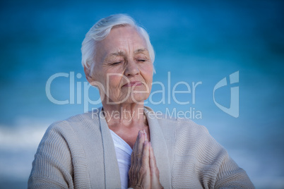 Senior woman relaxing with joined hands