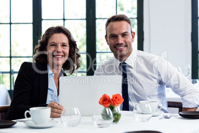 Portrait of business colleagues using a laptop while having a me