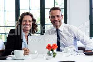 Portrait of business colleagues using a laptop while having a me