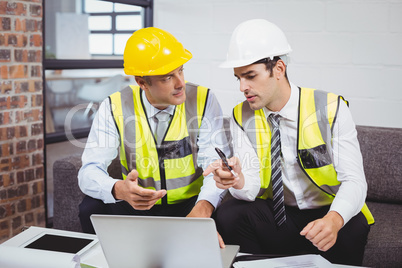 Male architects working on laptop