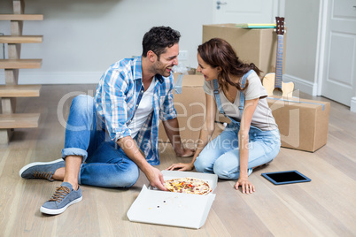 Happy couple having pizza while sitting