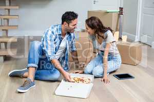 Happy couple having pizza while sitting