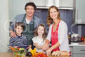 Portrait of smiling parents with children in kitchen