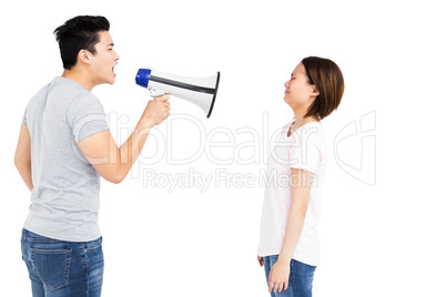 Angry man shouting at young woman on megaphone