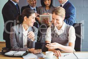 Businesswomen using digital tablet in conference room
