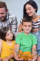 Happy young family sitting on sofa