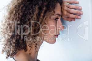 Upset woman leaning on wall