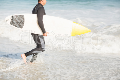 Surfer walking on the beach with a surfboard