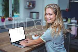 Happy attractive woman using laptop at table