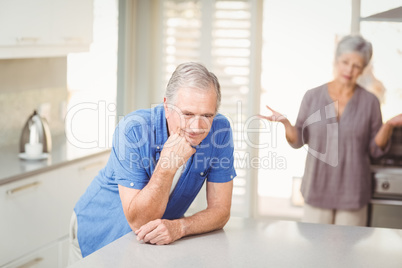 Senior man with woman arguing in background