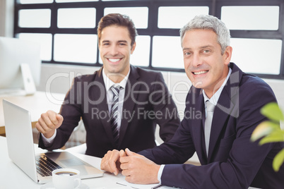 Portrait of smiling business people with laptop