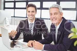 Portrait of smiling business people with laptop