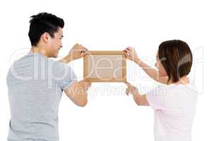 Young couple putting up picture frame