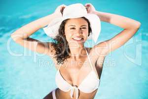 Portrait of happy woman wearing white hat and bikini relaxing by