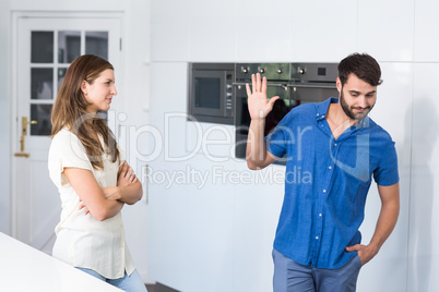 Man doing stop gesture to wife while arguing