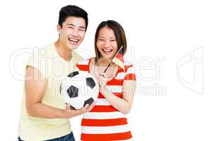 Excited couple holding football and flag