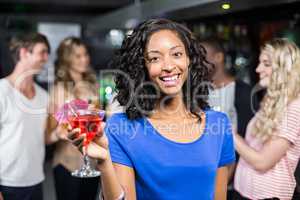 Smiling girl having a cocktail with her friends