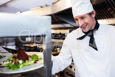 Chef handing dinner plate through order station