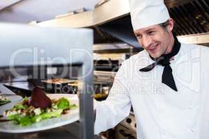 Chef handing dinner plate through order station