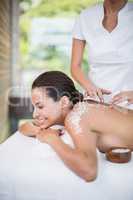 Young woman smiling while receiving spa treatment