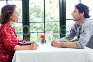 Middle-aged couple talking while having lunch