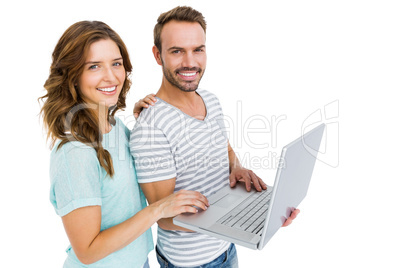 Portrait of happy young couple using laptop