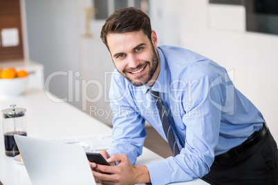 Businessman using mobile phone at home