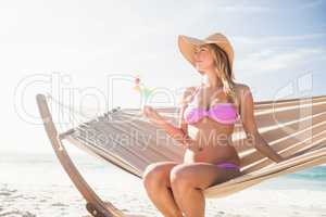 Woman drinking cocktail in hammock