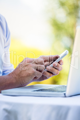 Casual businessman using laptop and smartphone